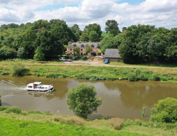 Vue de la maison avec la Vilaine et le chemin de halage V42. Parking voiture devant la maison et parkings supplémentaires à droite de la grange